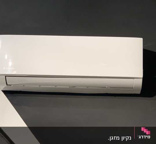 מזגן קיר לבן מותקן על קיר כהה